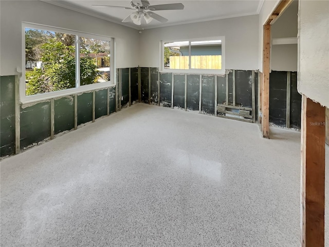 2826 46th St S, Gulfport, FL 33711 - spare room featuring speckled floor, ornamental molding, a healthy amount of sunlight, and ceiling fan