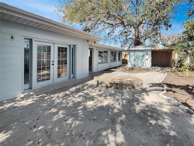 2826 46th St S, Gulfport, FL 33711 - exterior space with concrete block siding, an outdoor structure, french doors, and a storage shed