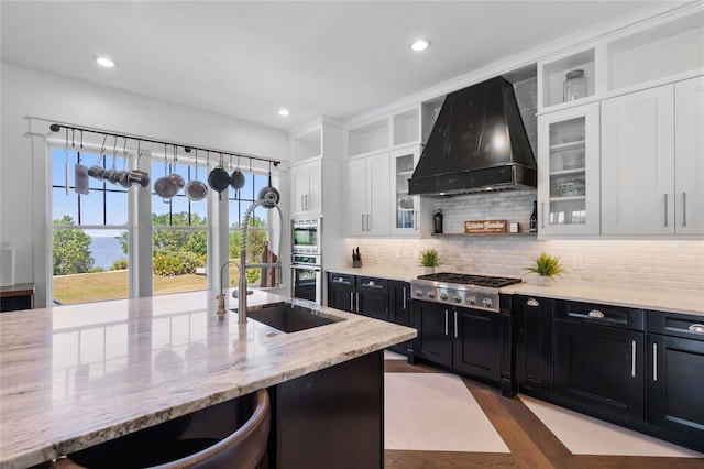 1224 Union Club Dr, Winter Garden, FL 34787 - kitchen featuring stainless steel appliances, wall chimney exhaust hood, dark cabinets, open shelves, and a sink