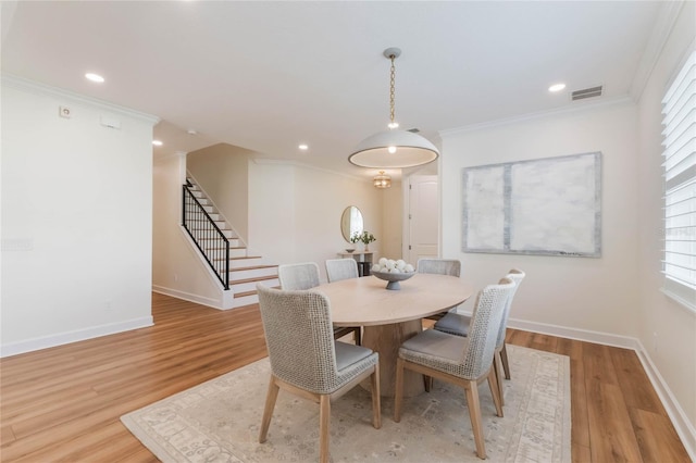 11826 Fiore Dr, Orlando, FL 32827 - dining space featuring light wood finished floors, crown molding, baseboards, and stairs