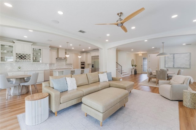 11826 Fiore Dr, Orlando, FL 32827 - living area with visible vents, light wood-style floors, ceiling fan, and stairway