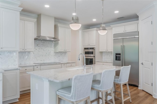11826 Fiore Dr, Orlando, FL 32827 - kitchen with visible vents, light wood-style flooring, appliances with stainless steel finishes, a sink, and wall chimney range hood