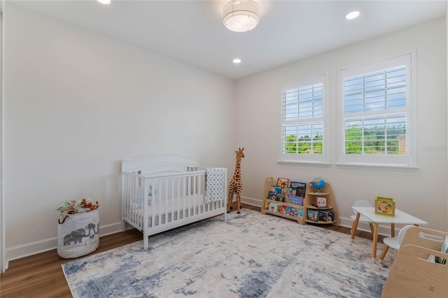 11826 Fiore Dr, Orlando, FL 32827 - unfurnished bedroom featuring baseboards, wood finished floors, a crib, and recessed lighting