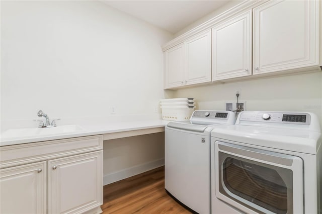11826 Fiore Dr, Orlando, FL 32827 - laundry area featuring washer and clothes dryer, a sink, light wood finished floors, baseboards, and cabinet space