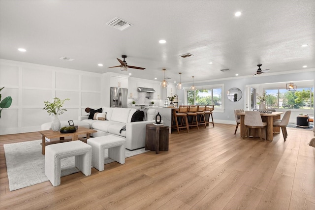 201 Cedarwood Dr, Maitland, FL 32751 - living room featuring visible vents, light wood-type flooring, a decorative wall, and a ceiling fan