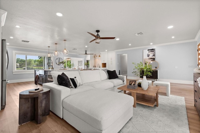 201 Cedarwood Dr, Maitland, FL 32751 - living room with light wood-type flooring, crown molding, visible vents, and a ceiling fan