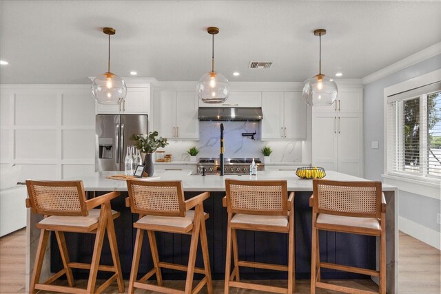 201 Cedarwood Dr, Maitland, FL 32751 - kitchen featuring light countertops, stainless steel fridge, under cabinet range hood, backsplash, and visible vents