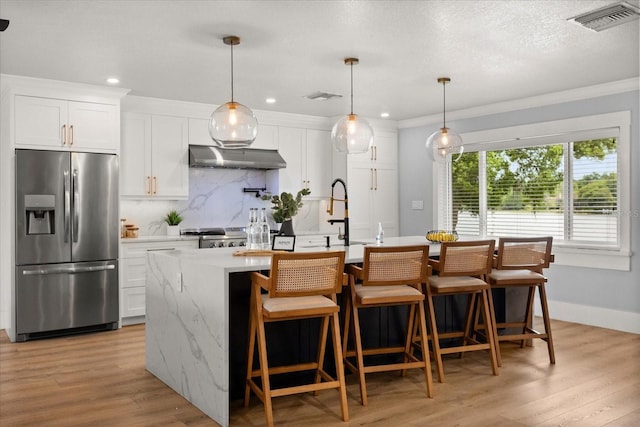 201 Cedarwood Dr, Maitland, FL 32751 - kitchen featuring stainless steel fridge with ice dispenser, a kitchen island with sink, visible vents, and tasteful backsplash