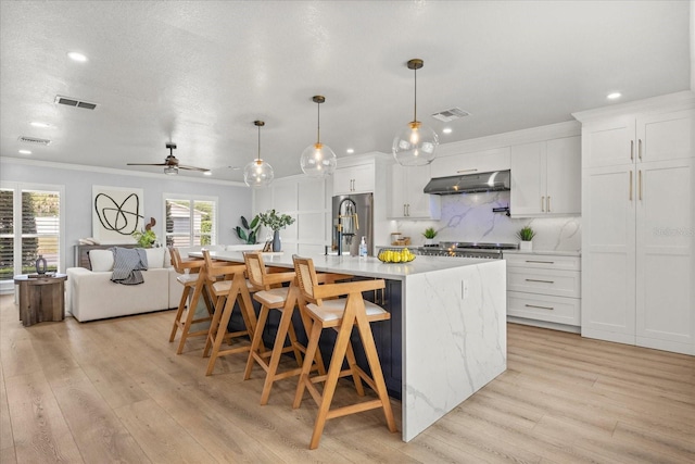 201 Cedarwood Dr, Maitland, FL 32751 - kitchen with stainless steel refrigerator, tasteful backsplash, under cabinet range hood, and visible vents
