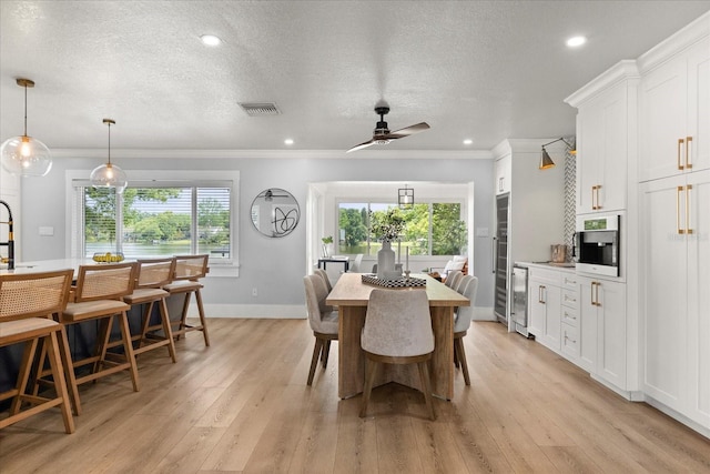 201 Cedarwood Dr, Maitland, FL 32751 - dining room featuring a textured ceiling, visible vents, crown molding, ceiling fan, and light wood-type flooring