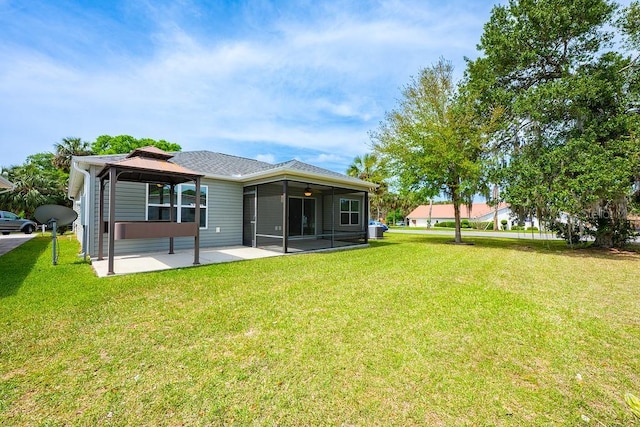 rear view of property with a lawn, a gazebo, a sunroom, and a patio