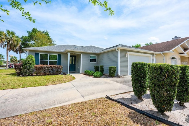 single story home featuring a garage, concrete driveway, and a front yard