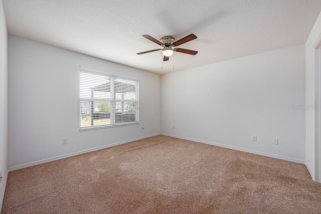 carpeted empty room featuring a textured ceiling, ceiling fan, and baseboards