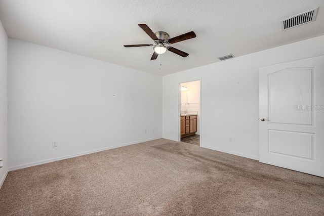 unfurnished bedroom featuring visible vents, carpet, and a textured ceiling