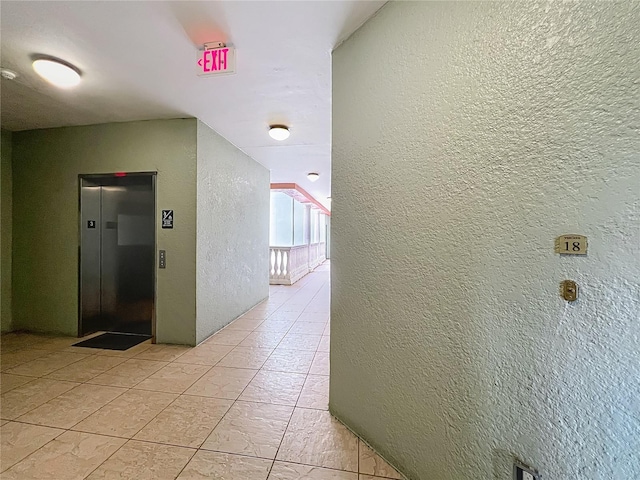8743 S The Esplanade Unit 18, Orlando, FL 32836 - hallway featuring elevator and a textured wall