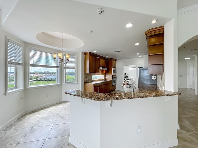 8743 S The Esplanade Unit 18, Orlando, FL 32836 - kitchen with open shelves, tasteful backsplash, light tile patterned floors, arched walkways, and a breakfast bar area
