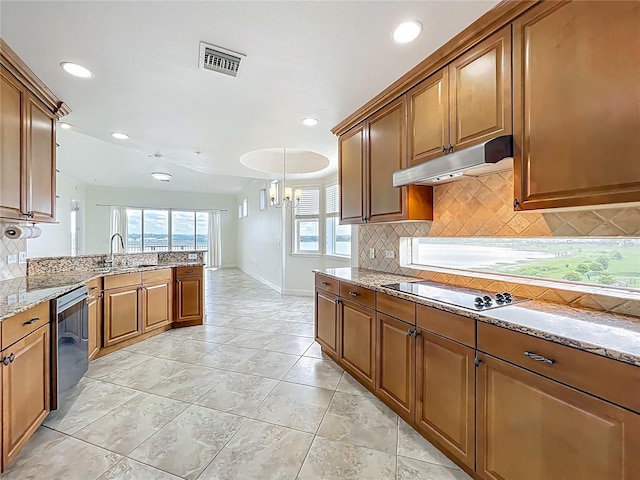 8743 S The Esplanade Unit 18, Orlando, FL 32836 - kitchen with black electric cooktop, under cabinet range hood, backsplash, stainless steel dishwasher, and brown cabinets