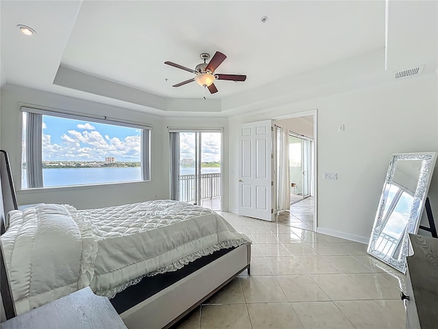 8743 S The Esplanade Unit 18, Orlando, FL 32836 - bedroom featuring access to outside, light tile patterned floors, a tray ceiling, a water view, and ceiling fan