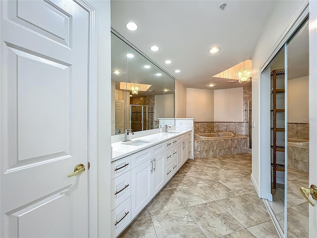 8743 S The Esplanade Unit 18, Orlando, FL 32836 - bathroom featuring a garden tub, double vanity, a chandelier, recessed lighting, and a shower with door