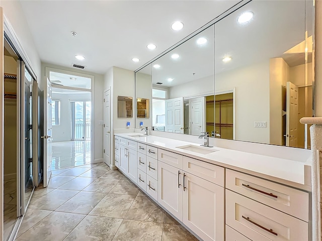 8743 S The Esplanade Unit 18, Orlando, FL 32836 - bathroom featuring double vanity, recessed lighting, a spacious closet, and tile patterned floors