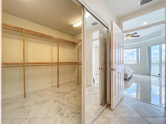 8743 S The Esplanade Unit 18, Orlando, FL 32836 - spacious closet with a ceiling fan and light marble finish floors