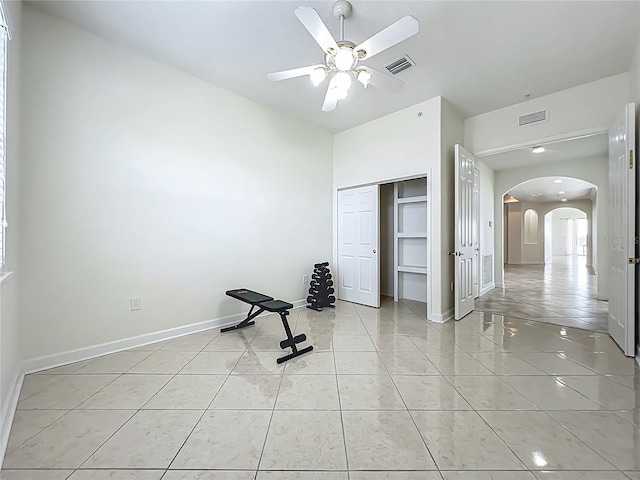 8743 S The Esplanade Unit 18, Orlando, FL 32836 - exercise room with arched walkways, ceiling fan, and light tile patterned flooring