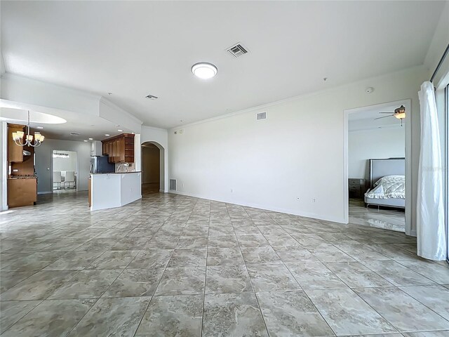 8743 S The Esplanade Unit 18, Orlando, FL 32836 - unfurnished living room with a chandelier, arched walkways, crown molding, and ceiling fan