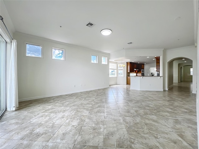 8743 S The Esplanade Unit 18, Orlando, FL 32836 - unfurnished living room with arched walkways and ornamental molding