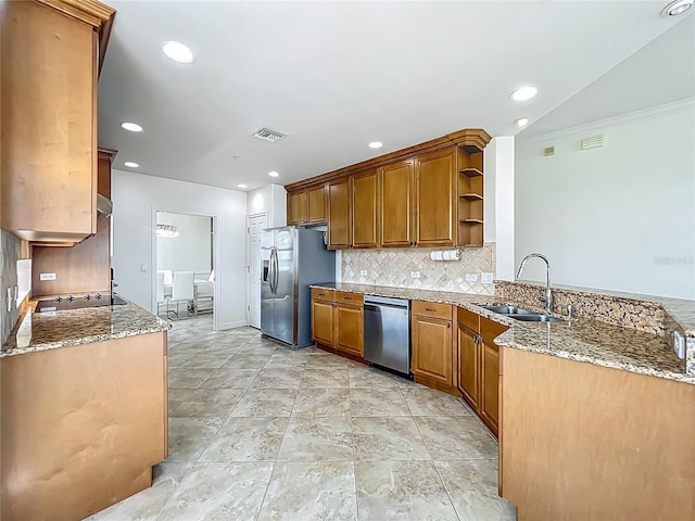 8743 S The Esplanade Unit 18, Orlando, FL 32836 - kitchen with appliances with stainless steel finishes, open shelves, decorative backsplash, light stone counters, and a peninsula