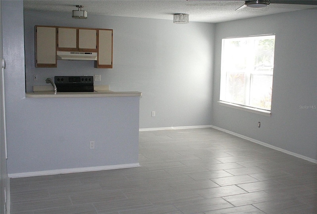 interior space featuring baseboards, a textured ceiling, and a healthy amount of sunlight