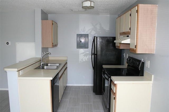 kitchen featuring light countertops, a peninsula, range hood, a sink, and black appliances