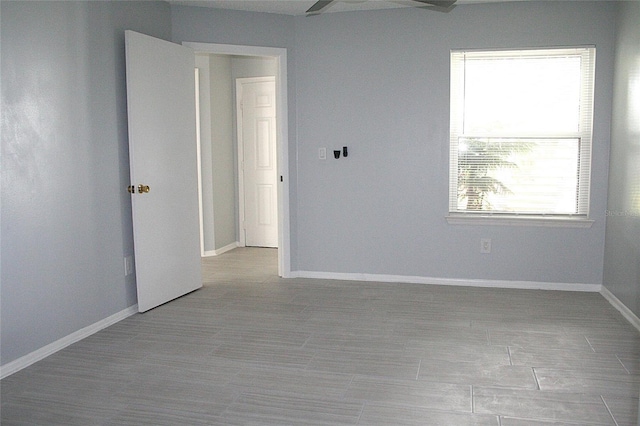 unfurnished room featuring baseboards and a ceiling fan