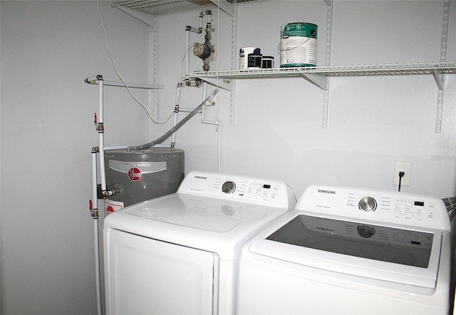 laundry area featuring water heater, washer and dryer, and laundry area
