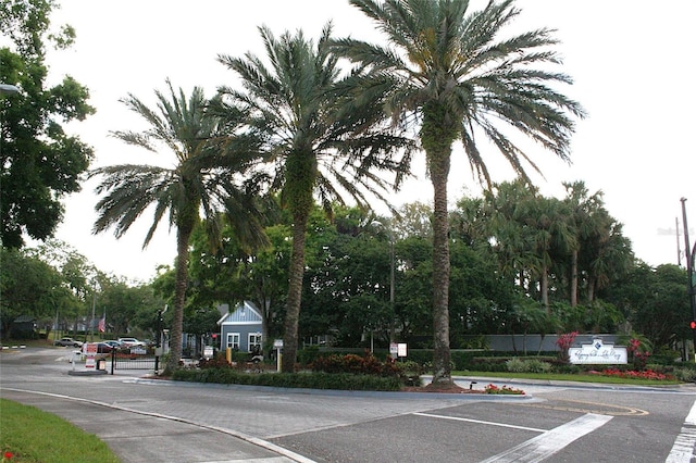 view of street featuring a gated entry and curbs