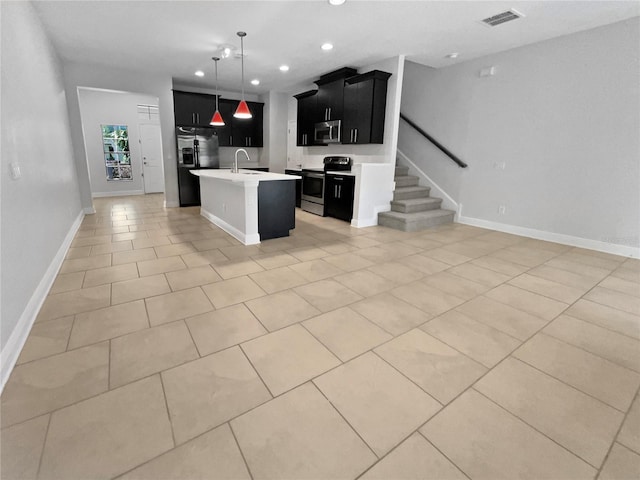 kitchen featuring open floor plan, visible vents, dark cabinets, and stainless steel appliances