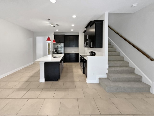 kitchen featuring light countertops, a sink, stainless steel fridge, dark cabinetry, and black / electric stove