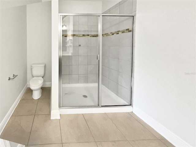 full bath with toilet, tile patterned floors, and a shower stall