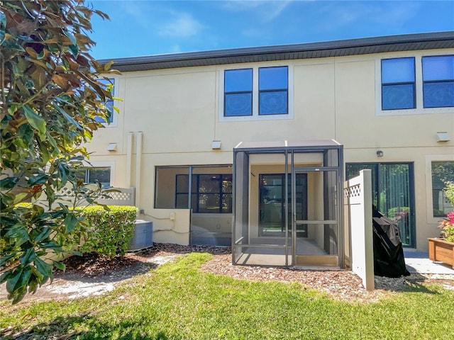 back of property featuring stucco siding, a sunroom, and central air condition unit