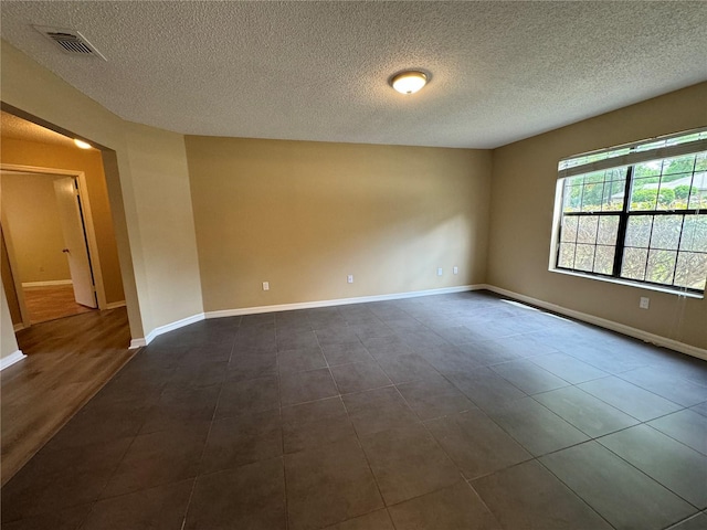 2132 Majestic Woods Blvd, Apopka, FL 32712 - unfurnished room with dark tile patterned floors, baseboards, a textured ceiling, and visible vents