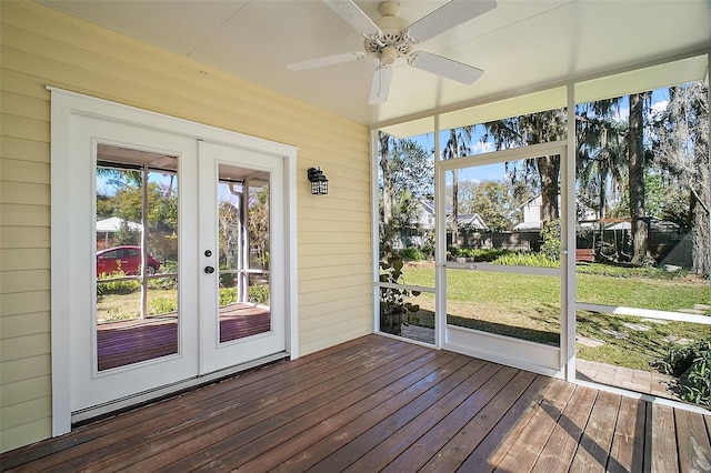 unfurnished sunroom featuring ceiling fan and french doors