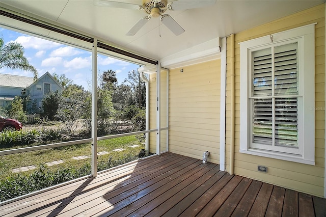 unfurnished sunroom featuring a ceiling fan and plenty of natural light