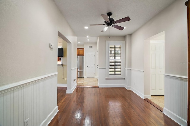 spare room featuring wainscoting, ceiling fan, hardwood / wood-style flooring, and a textured ceiling