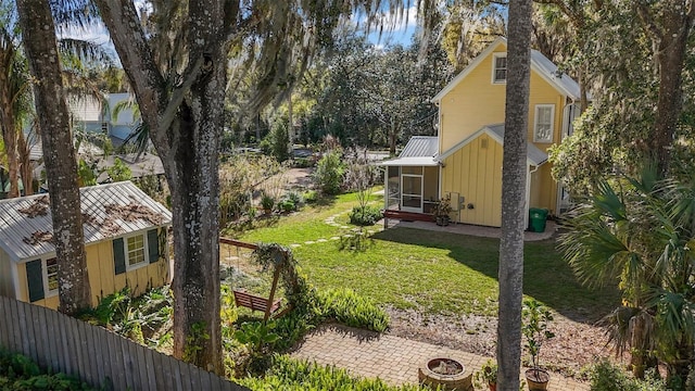 view of side of home featuring board and batten siding, a yard, a sunroom, and fence
