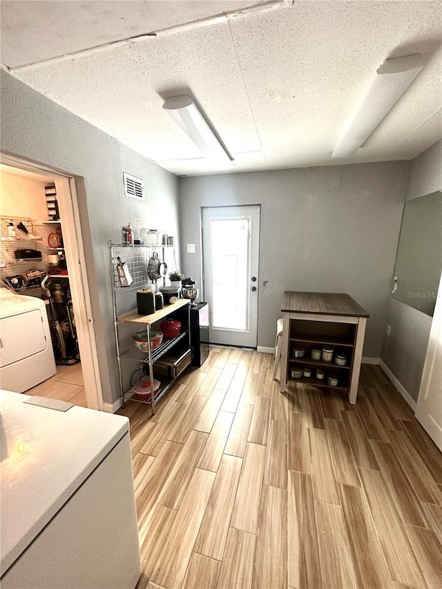 1098 Henry Balch Dr, Orlando, FL 32810 - miscellaneous room with visible vents, a textured ceiling, light wood-style flooring, and washer / clothes dryer