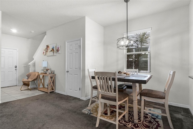 carpeted dining area featuring a chandelier, tile patterned flooring, baseboards, and a textured ceiling