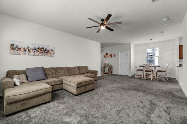 carpeted living room featuring a textured ceiling, baseboards, a ceiling fan, and visible vents