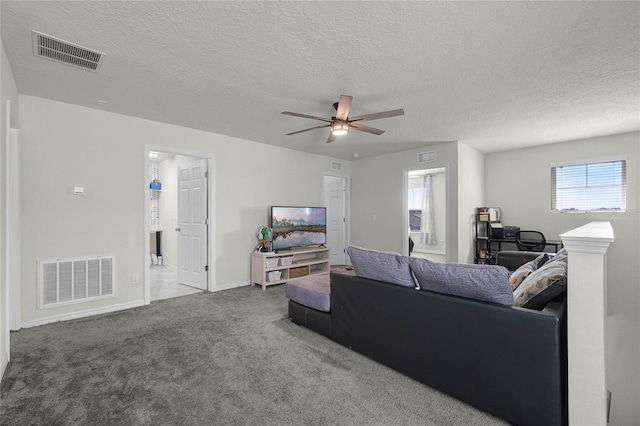 living room featuring carpet flooring, visible vents, and ceiling fan