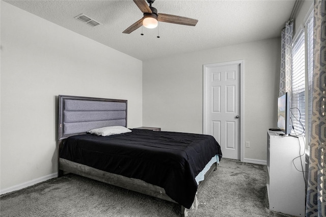 bedroom featuring carpet flooring, visible vents, baseboards, and a textured ceiling