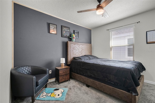 carpeted bedroom with a textured ceiling, baseboards, and a ceiling fan