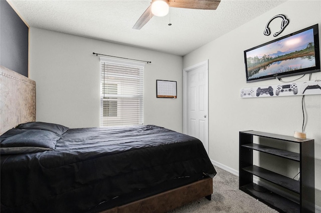 carpeted bedroom with a textured ceiling, baseboards, and ceiling fan